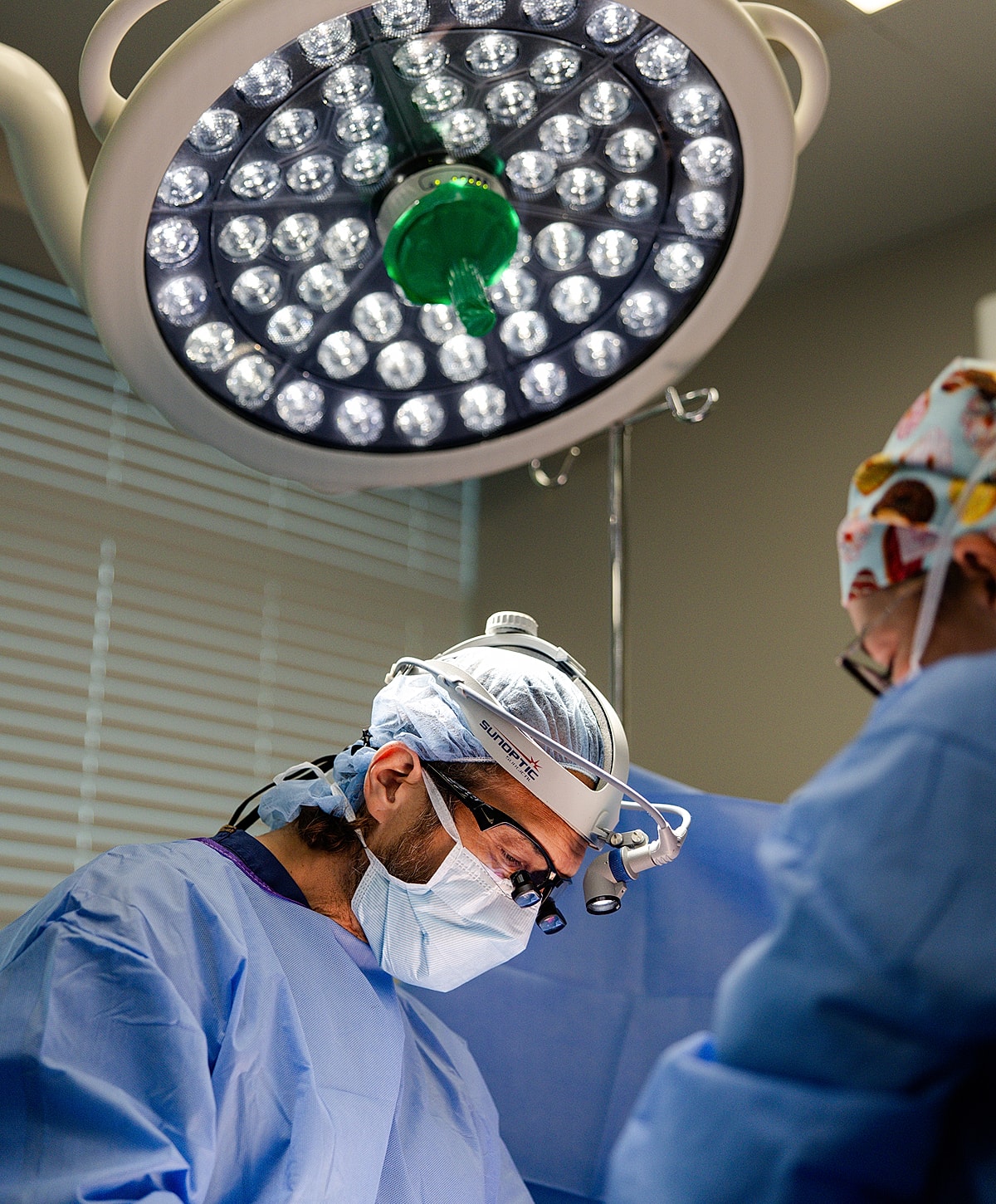 Surgeons performing a procedure under surgical lights.