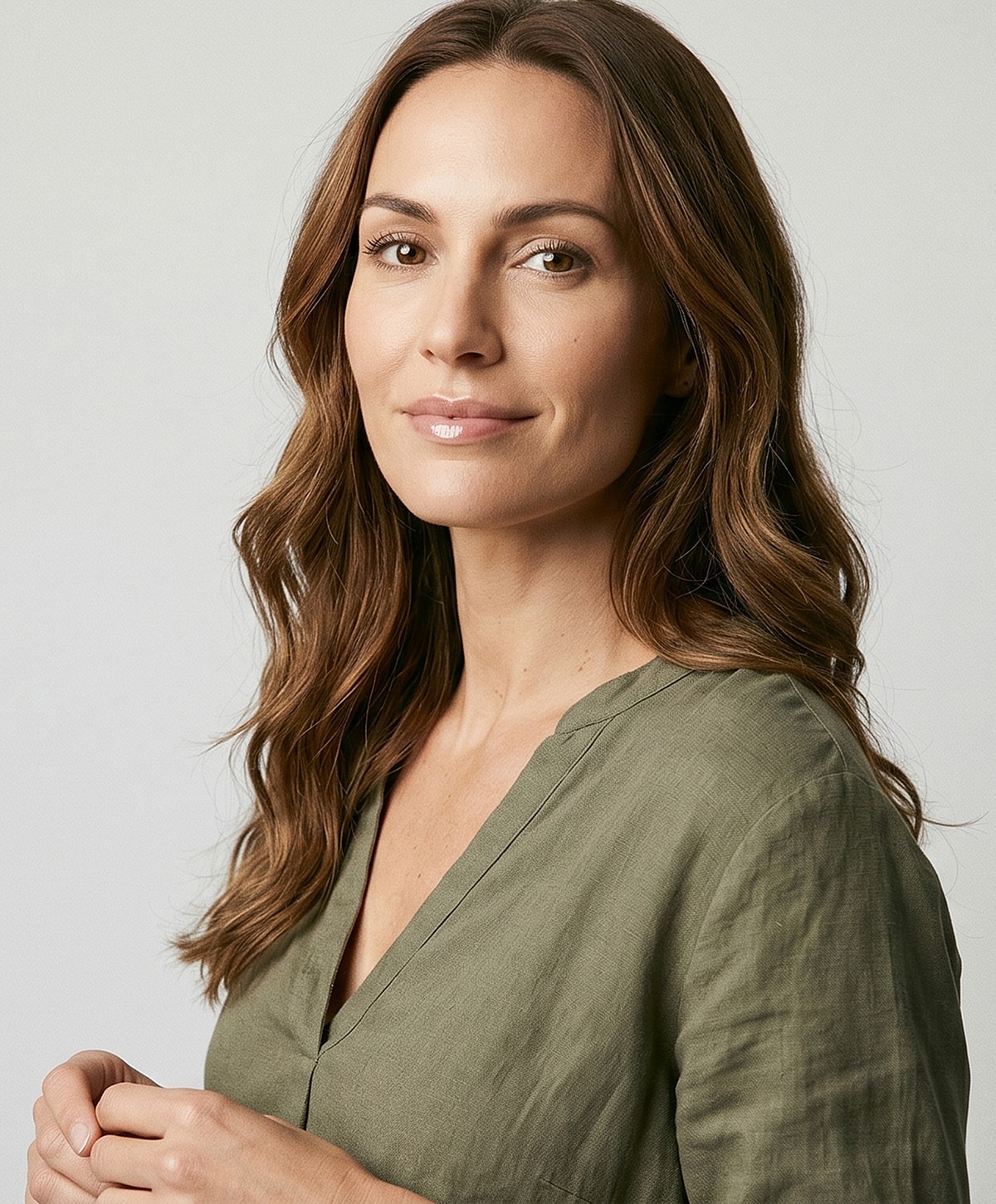 Woman with long hair in olive green top.