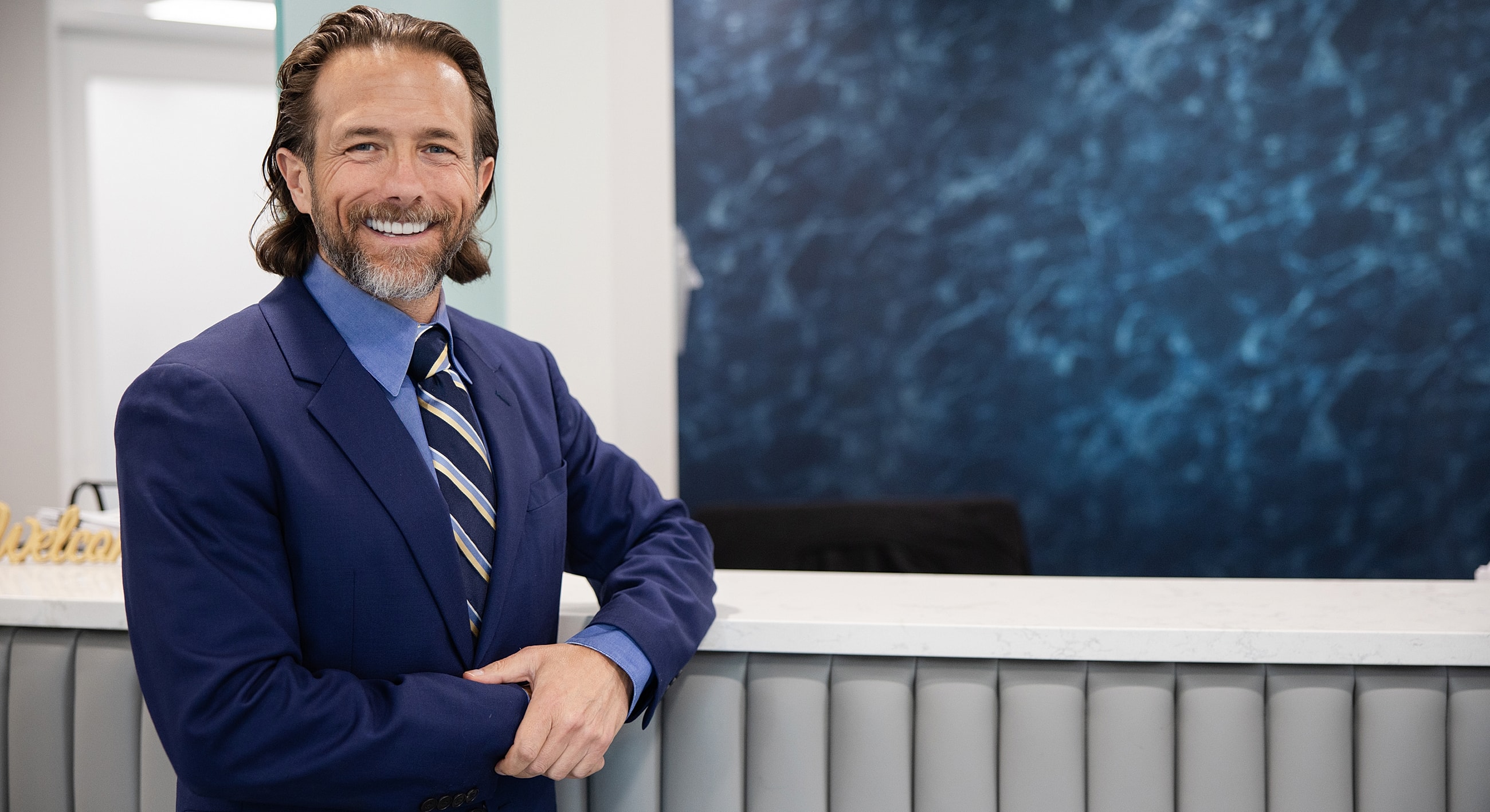 Professional man smiling at reception desk.